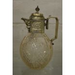 A cut glass claret jug with plated mounts.