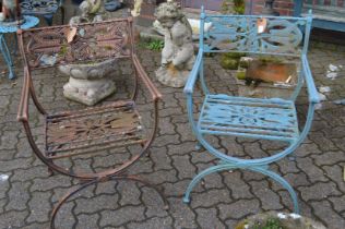A pair of cast metal garden armchairs.