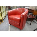 A red leather cloth upholstered armchair.