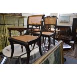 A pair of Regency ebonised and canework dining chairs.