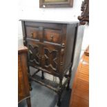 An oak cupboard with turned supports.