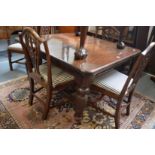 A mahogany extending dining table with two leaves (lacking winding handle).