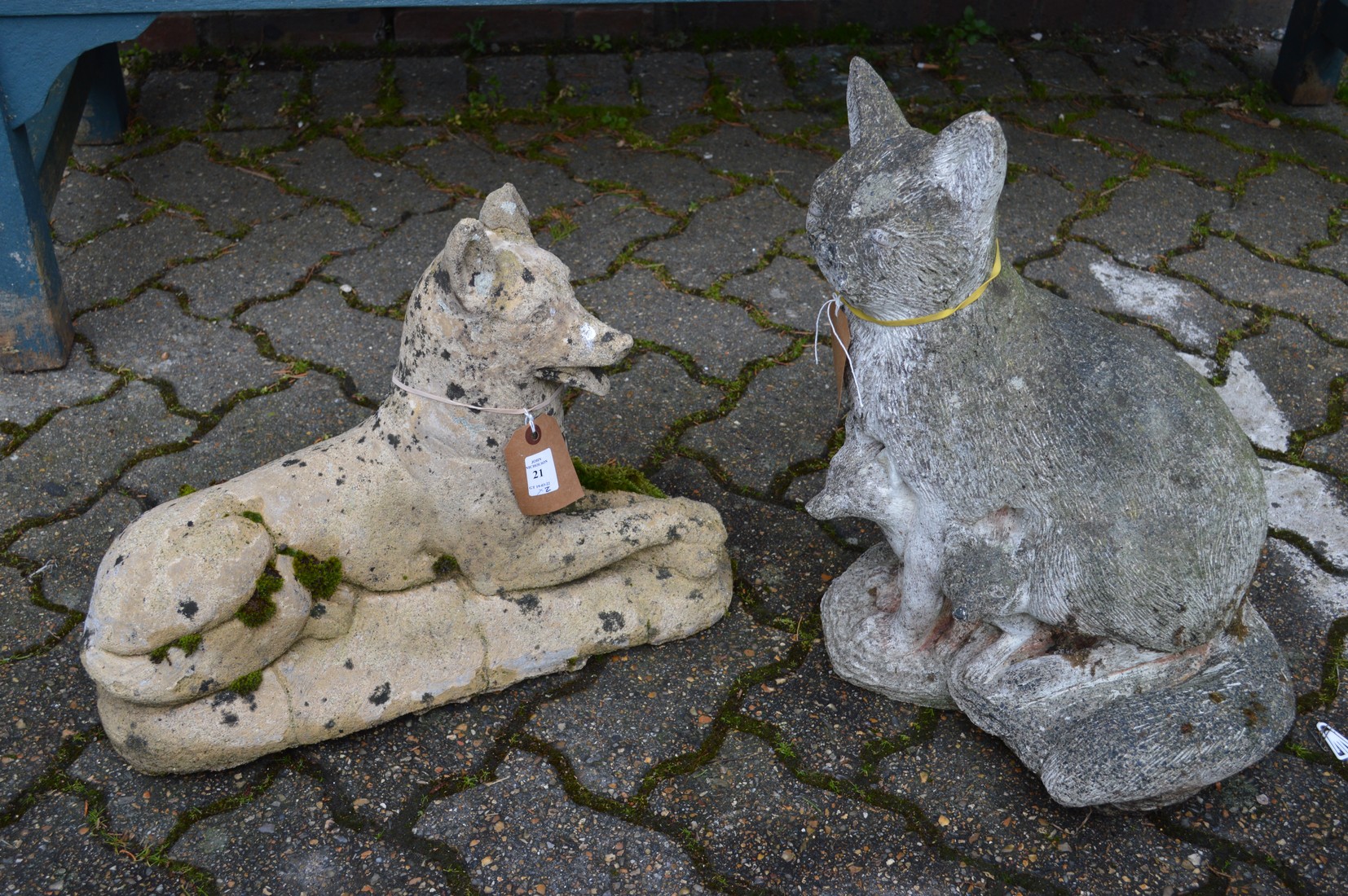 Two composite garden ornaments of a dog and a cat.