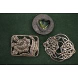 Decorative silver and other brooches.
