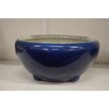 A Chinese blue ground circular bowl on moulded feet (cracked).