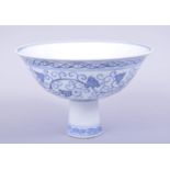 A CHINESE BLUE AND WHITE MING STYLE PORCELAIN STEM CUP, painted with scrolling foliate decoration,