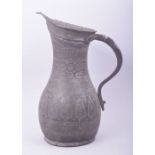 AN ISLAMIC ENGRAVED METAL EWER, 30cm high.