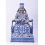 A LARGE CHINESE POWDER BLUE GLAZE POTTERY SEATED FIGURE of a god, the figure seated upon a throne