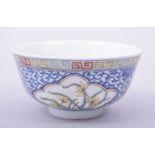 AN EARLY 20TH CENTURY CHINESE BLUE AND WHITE / POLYCHROME BOWL, the exterior decorated with flowers,