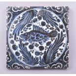 A CHINESE BLUE AND WHITE GLAZED TEMPLE TILE, the tile painted with a fish and algae, 20cm square.