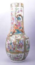 A LARGE CHINESE CANTON FAMILLE ROSE PORCELAIN VASE, painted with panels of figures in a courtyard,
