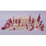 A QUANTITY OF CARVED IVORY CHESS PIECES, including a quantity of stained red pieces.