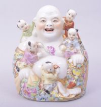 A CHINESE PORCELAIN LAUGHING BUDDHA, with five children, 15cm high.