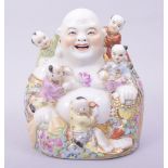 A CHINESE PORCELAIN LAUGHING BUDDHA, with five children, 15cm high.