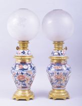 A PAIR OF SAMSON PORCELAIN JAPANESE IMARI AND GILT METAL LAMPS, with globular glass shades, 51cm