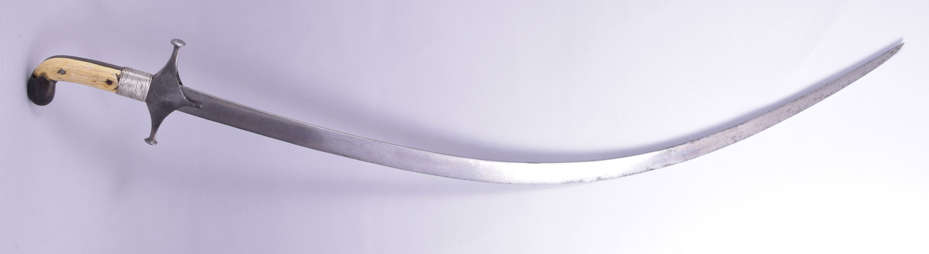 A FINE INDO PERSIAN SHAMSHIR SWORD with watered steel blade and cross guard, with bone handle,