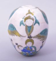 A TURKISH ARMENIAN GLAZED POTTERY HANGING EGG FORM ORNAMENT, painted with the virgin and child, 9.