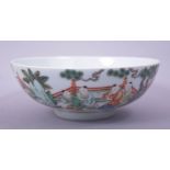 A CHINESE FAMILLE VERTE PORCELAIN BOWL, decorated with numerous figures in a garden, with eight