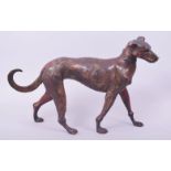 A BRONZE MODEL OF A DOG, with traces of gilt and red paint, 31cm long.