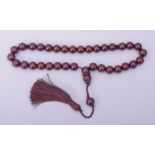 AN ISLAMIC CHERRY BAKELITE SET OF TASBIH PRAYER BEADS, comprising of 34 beads, two small dividing