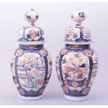 A PAIR OF JAPANESE IMARI PORCELAIN JARS AND COVERS, decorated in the imari palette with panels of