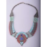 A TURQUOISE AND CORAL INSET WHITE METAL NECKLACE.