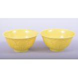 A PAIR OF CHINESE YELLOW GLAZED PORCELAIN CUPS, each with six character mark to base, 7.5cm