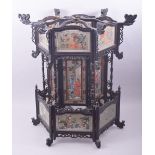 A CHINESE EBONISED WOOD AND REVERSE PAINTED GLASS PANEL LANTERN, painted with figures and native