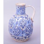 A RARE TURKISH OTTOMAN KUTAHYA POTTERY WATER JUG, decorated in blue and white with floral motifs,