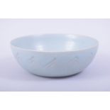 A CHINESE CELADON CIRCULAR BOWL, the exterior with incised petal design, 18.5cm diameter.