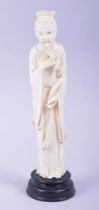 A CHINESE CARVED IVORY FIGURE OF A SAGE holding a ruyi scepter, mounted to a hardwood base, 23cm