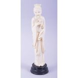 A CHINESE CARVED IVORY FIGURE OF A SAGE holding a ruyi scepter, mounted to a hardwood base, 23cm