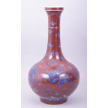 A CHINESE COPPER RED GROUND PORCELAIN VASE, decorated with blue and white dragons amongst stylised