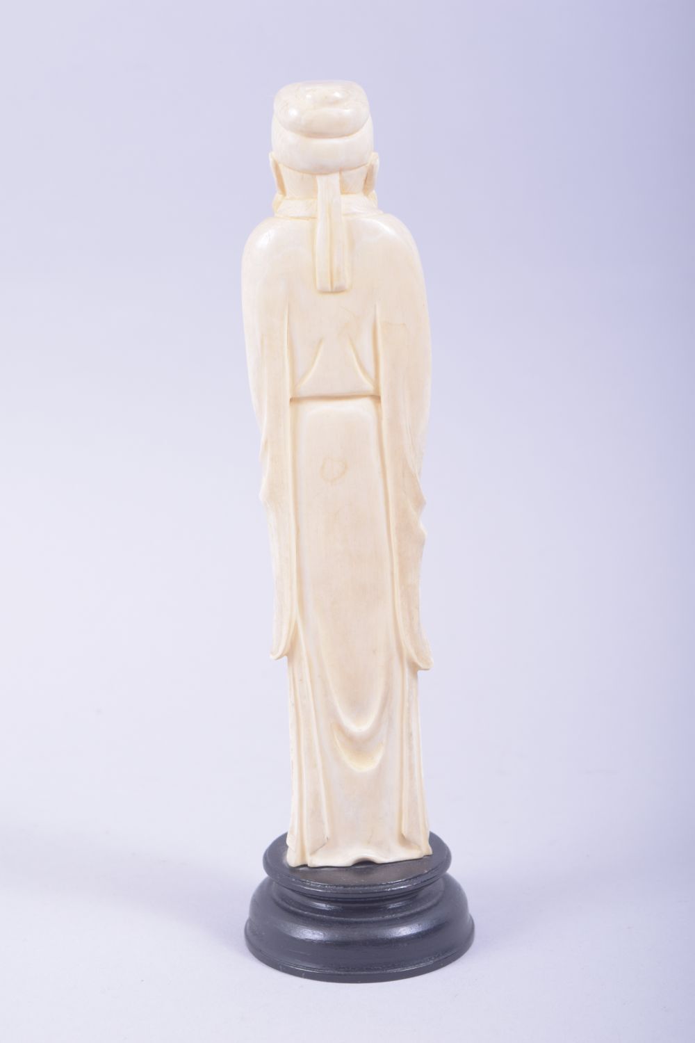 A CHINESE CARVED IVORY FIGURE OF A SAGE holding a flower, mounted to a hardwood base, 23cm high. - Image 3 of 7