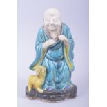 A MING STYLE FAHUA LOUHAN WITH LION FIGURE, the figure with the head and hands unglazed, 21.5cm