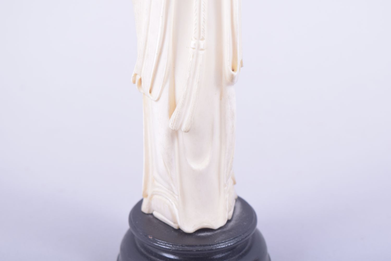A CHINESE CARVED IVORY FIGURE OF A SAGE holding a flower, mounted to a hardwood base, 23cm high. - Image 7 of 7