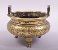 A CHINESE BRONZE TWIN HANDLE TRIPOD CENSER, with engraved and chased decoration, the base with six-