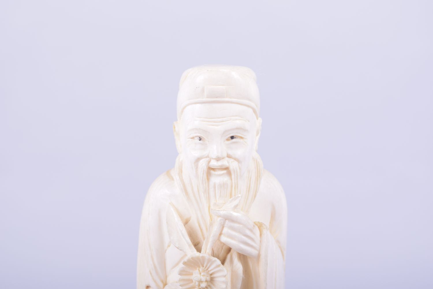 A CHINESE CARVED IVORY FIGURE OF A SAGE holding a flower, mounted to a hardwood base, 23cm high. - Image 5 of 7