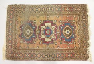 A SMALL PERSIAN RUG, rust ground with three medallions. 4ft x 2ft 8ins.