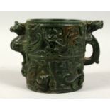 A CHINESE TWO HANDLED CIRCULAR JADE BRUSH POT with figures, birds etc. in relief. 5ins