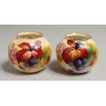 A PAIR OF ROYAL WORCESTER VASES painted with autumnal leaves and berries by Kitty Blae. Signed K.