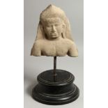 AN ANTIQUITY STONE FIGURE, POSSIBLY INDIAN. 10ins x 9ins on a stand.