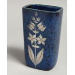 A SMALL BLUE MOTTLED VASE with sliver flowers. 5ins high.