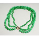 A GOOD SET OF JADE BEADS with gold clasp.