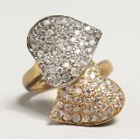 A 9CT GOLD DIAMOND CROSS OVER HEART SHAPED RING.