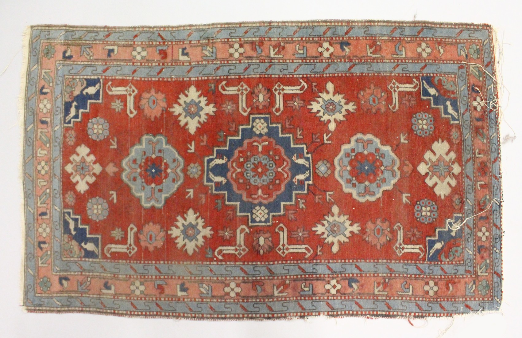 A SMALL PERSIAN RUG, red ground with geometric decoration. 4ft 2ins x 2ft 7ins