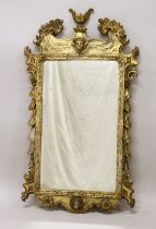 A GOOD GEORGE III DESIGN CARVED WOOD AND GILDED MIRROR with acanthus scrolls, masks and urns. 3ft