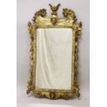 A GOOD GEORGE III DESIGN CARVED WOOD AND GILDED MIRROR with acanthus scrolls, masks and urns. 3ft