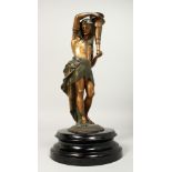 A PAINTED BRONZE FIGURE OF AN EGYPTIAN MAN holding a torch. 11ins high on a circular marble base.
