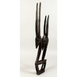A CARVED WOOD TRIBAL FIGURE OF ANTELOPES. 31ins long.